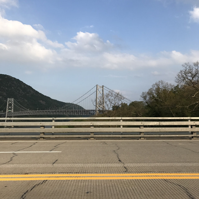 a bridge and a mountain in the distance viewed from another, smaller bridge